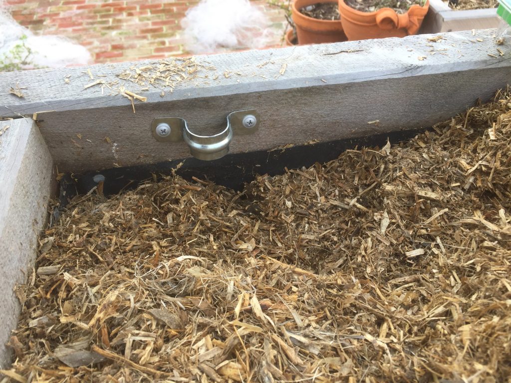 Clamp on the side of the wicking bed.