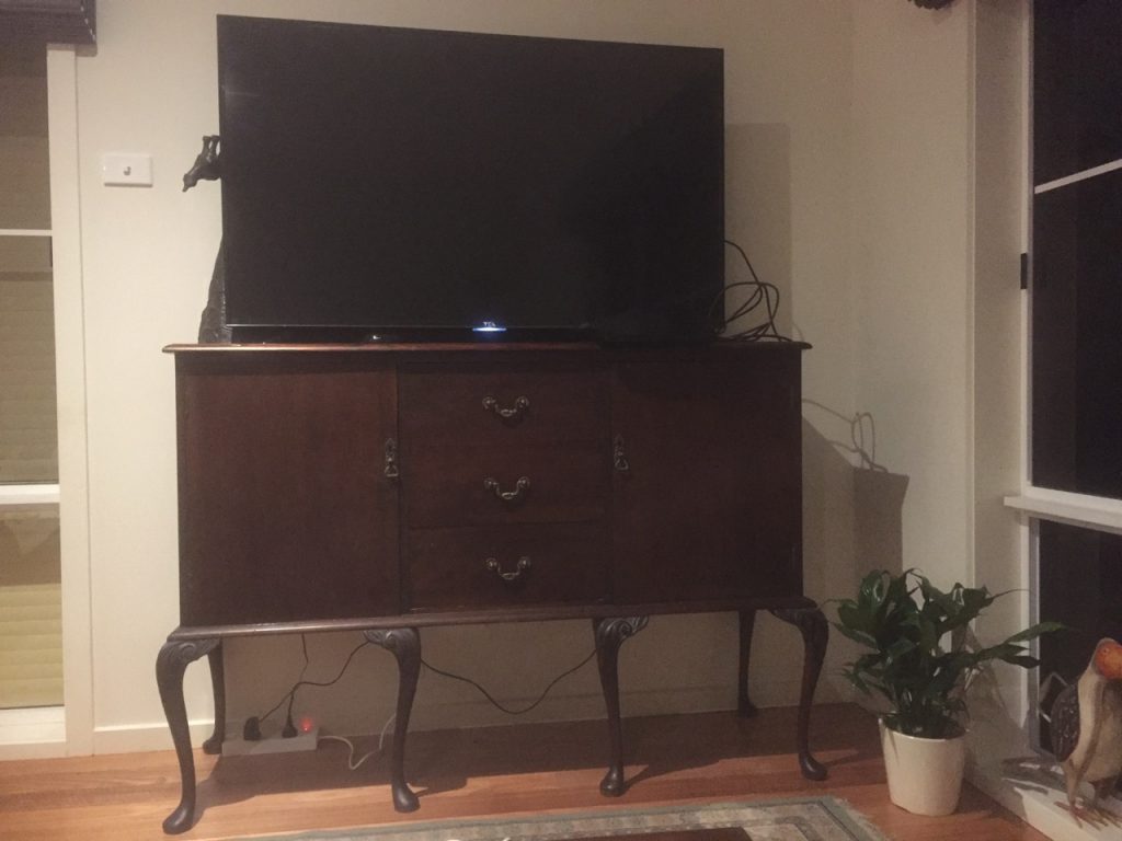 Wooden tv cabinet with 6 very long, curved legs.