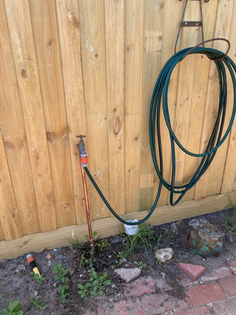 Hose hanging up on the brand-new fence.