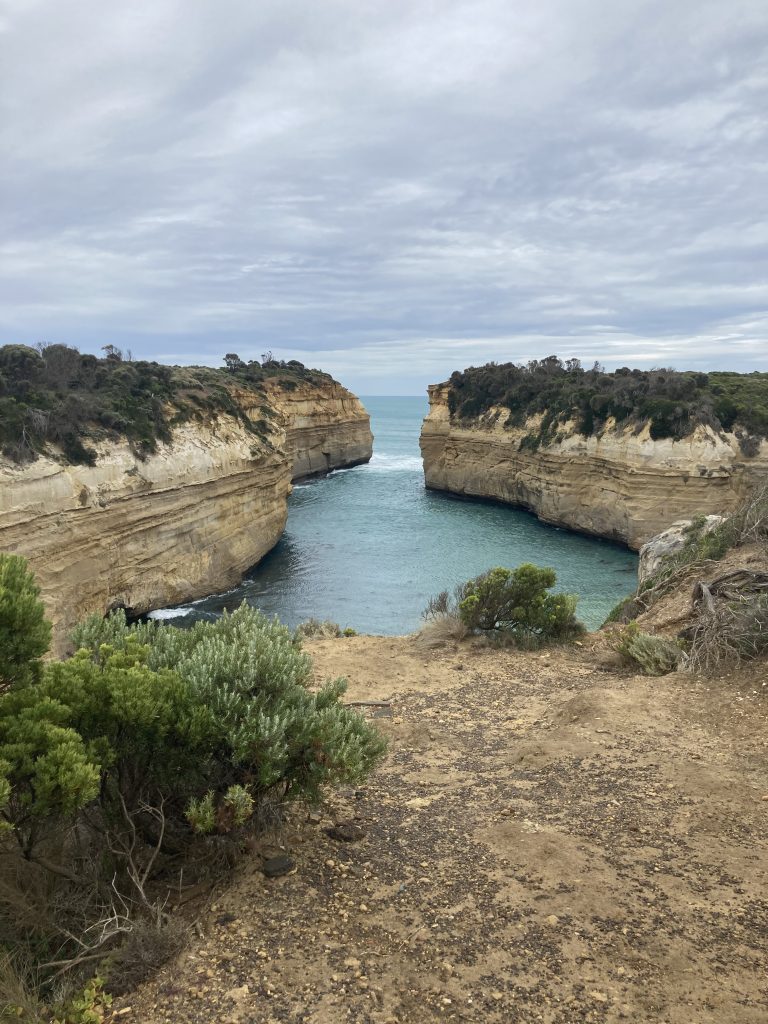 Beach with cliffs to a narrow opening to the open ocean.